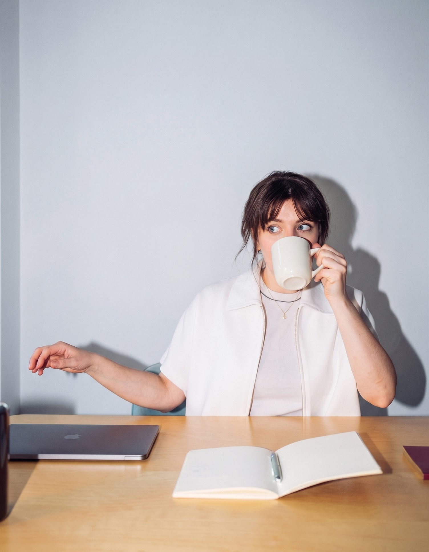 Young entrepreneur at her desk with coffee and a notebook
