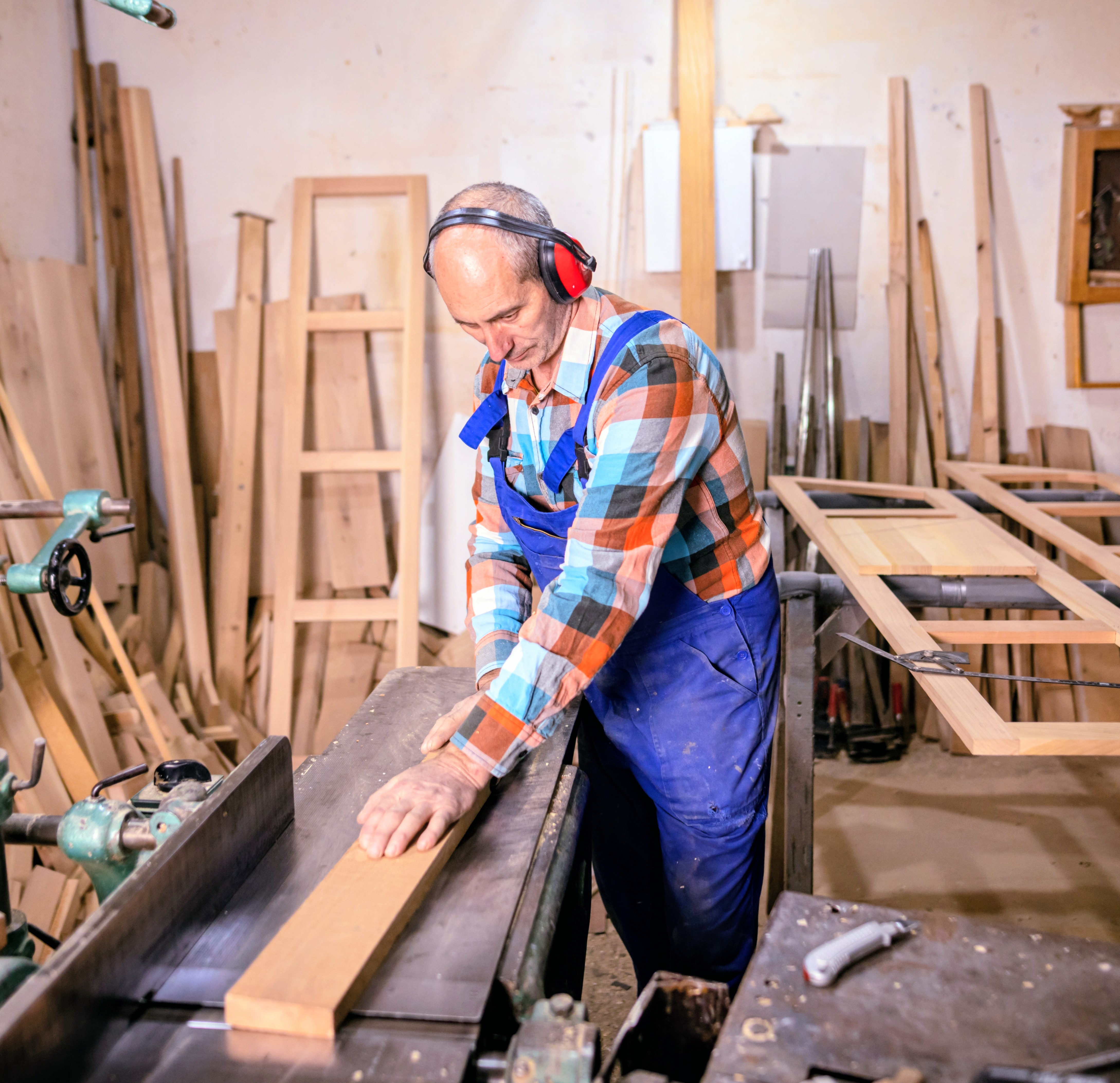 Craftsman cutting wood in his workshop